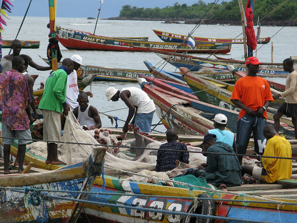Local fishermen tend their boats in Tombo, a busy fishing village in Sierra Leone. The nation is one of several in West Africa dogged by foreign vessels engaged in illegal, underreported, or unregulated fishing. Photo credit: BBC World Service.