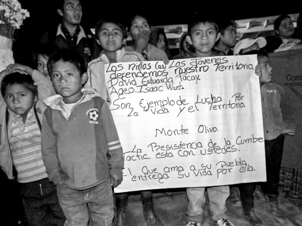 Children carry a banner commemorating two children allegedly killed in 2013 by an employee of the company that owns the Santa Rita dam. The banner reads in part "They are examples of the struggle for life and land." Photo credit: Peoples' Council of Tezulutlán.