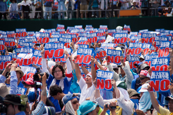 Protesters in the Okinawan city of Naha carry signs opposing construction of a new US air base on May 17, 2015. The base would threaten habitat critical for dugongs and is fiercely opposed by local residents. Photo credit: Greenpeace Japan.