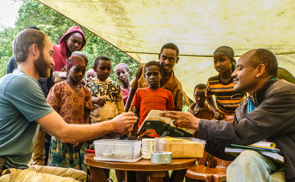 Evan Buechley (left) gives a bird banding demonstration to Ethiopian school children, with the help of Girma Ayalew (right) of the Ethiopia Wildlife Conservation Authority. Outreach and capacity building through hands-on training and job creation are key aspects of our research in Ethiopia. Photo credit: Evan Buechley.